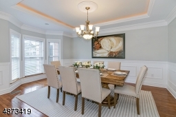 Elegant formal  dining room with tray ceiling; custom millwork, beautiful chandelier included