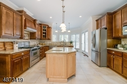 Truly a gourmet kitchen -- ample cabinetry, center island with pendant lighting and prep sink