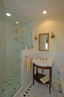 Lovely bathroom with marble floor, double shower heads, frameless glass shower doors.