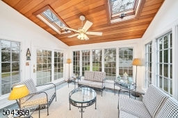 The three season sunroom has windows on 3 sides, a door to the rear yard, and a vaulted ceiling with skylights.