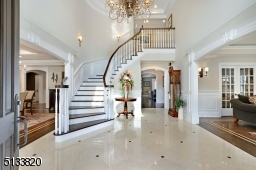 Grande foyer with marble tile floor and beautiful turned staircase.