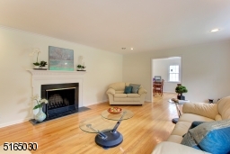 Spacious Living Room with hardwood floors and wood burning fireplace.