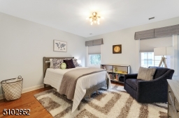 Bedroom 2 with deep baseboard moldings, hardwood floors, modern sputnik, light fixture, two windows, deep baseboard moldings and a closet