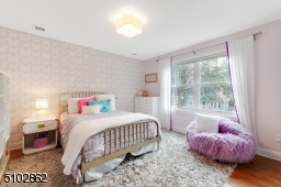 Bedroom 3 with deep baseboard moldings, hardwood floors, double window, modern flush mount, clover light fixture and a double closet
