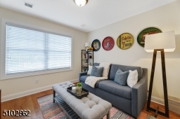 Bedroom 4 / Office featuring deep baseboard moldings, hardwood floors, double window, flush mount light and double closet