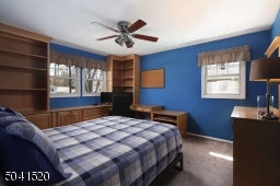 Bedroom with ceiling fan, custom built-ins and closet storage.